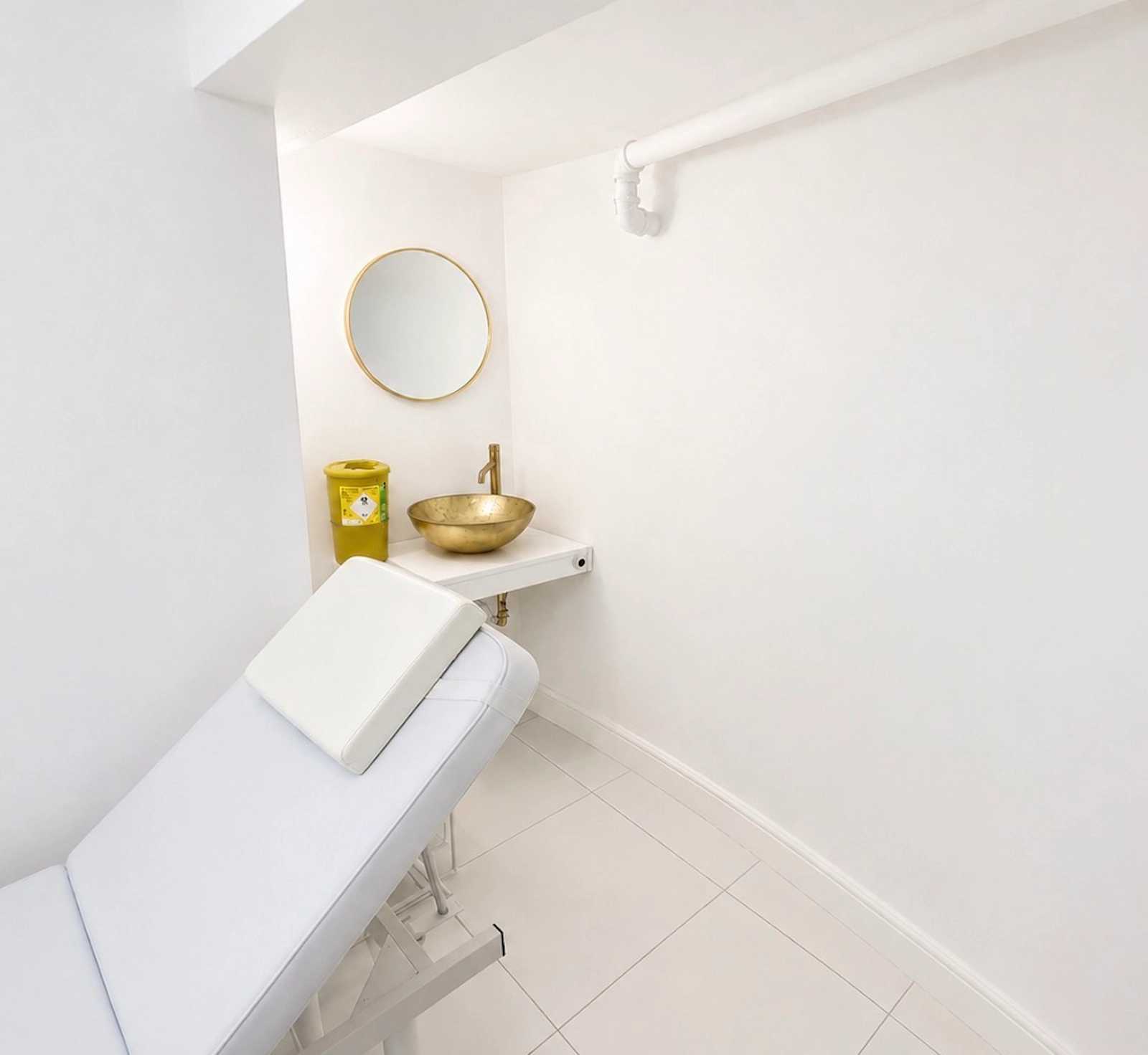 Akter Clinic treatment room with treatment bed and clinical sink
